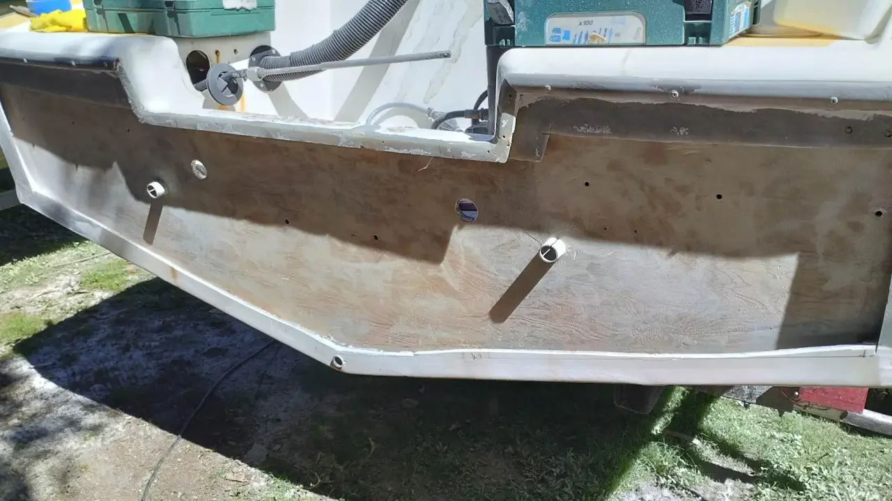Préparation pour refaire le tableau arrière d'un bateau. Des outils et des matériaux sont visibles.