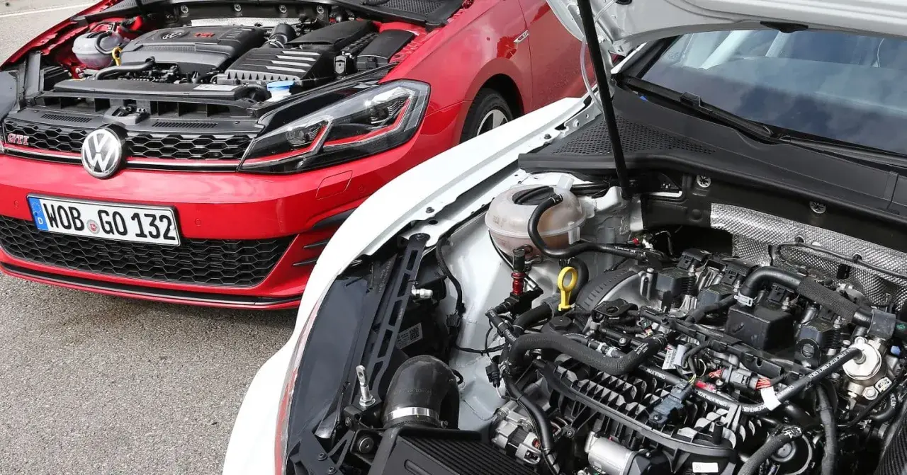 Dos Volkswagen Golf 7 GTI, uno rojo y otro blanco, con capós abiertos mostrando sus motores.