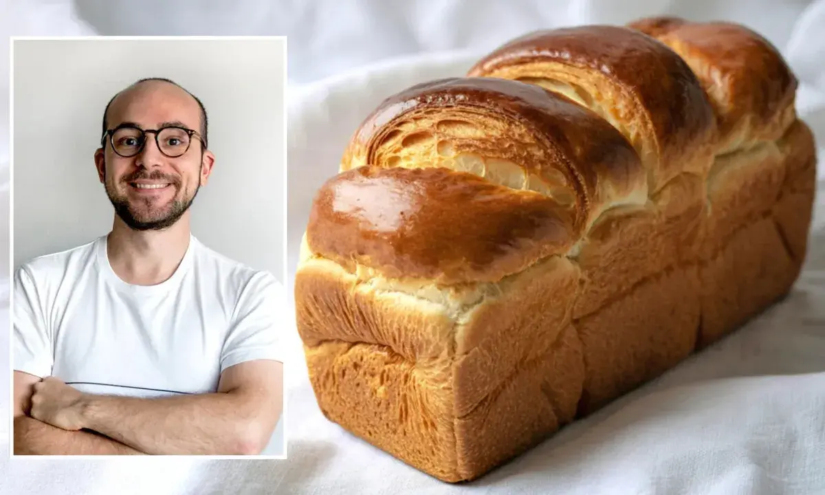 Un homme souriant à côté d'une brioche dorée. La cuisson de cette brioche, avec ou sans chaleur tournante, a donné un résultat parfait.