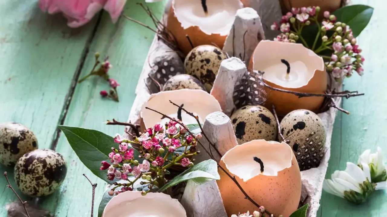 Osterdeko selber basteln mit Naturmaterialien: Eierschalenkerzen, Wachteleier und zarte Blüten auf Holz.