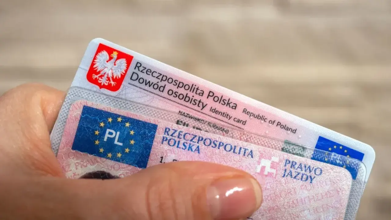Dłoń trzyma polski dowód osobisty i prawo jazdy. Czas na wymianę prawa jazdy bezterminowego?