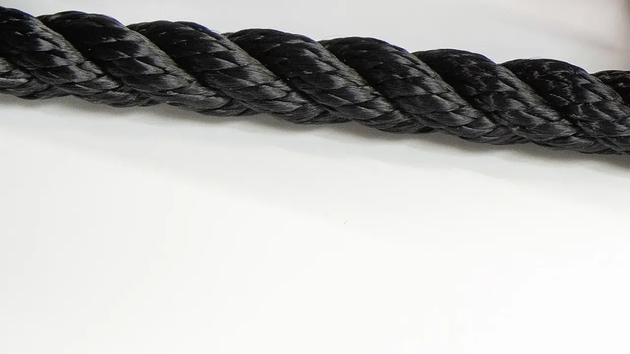 Gros cordage noir tressé, prêt à sécuriser un navire lors de sa prochaine traversée.