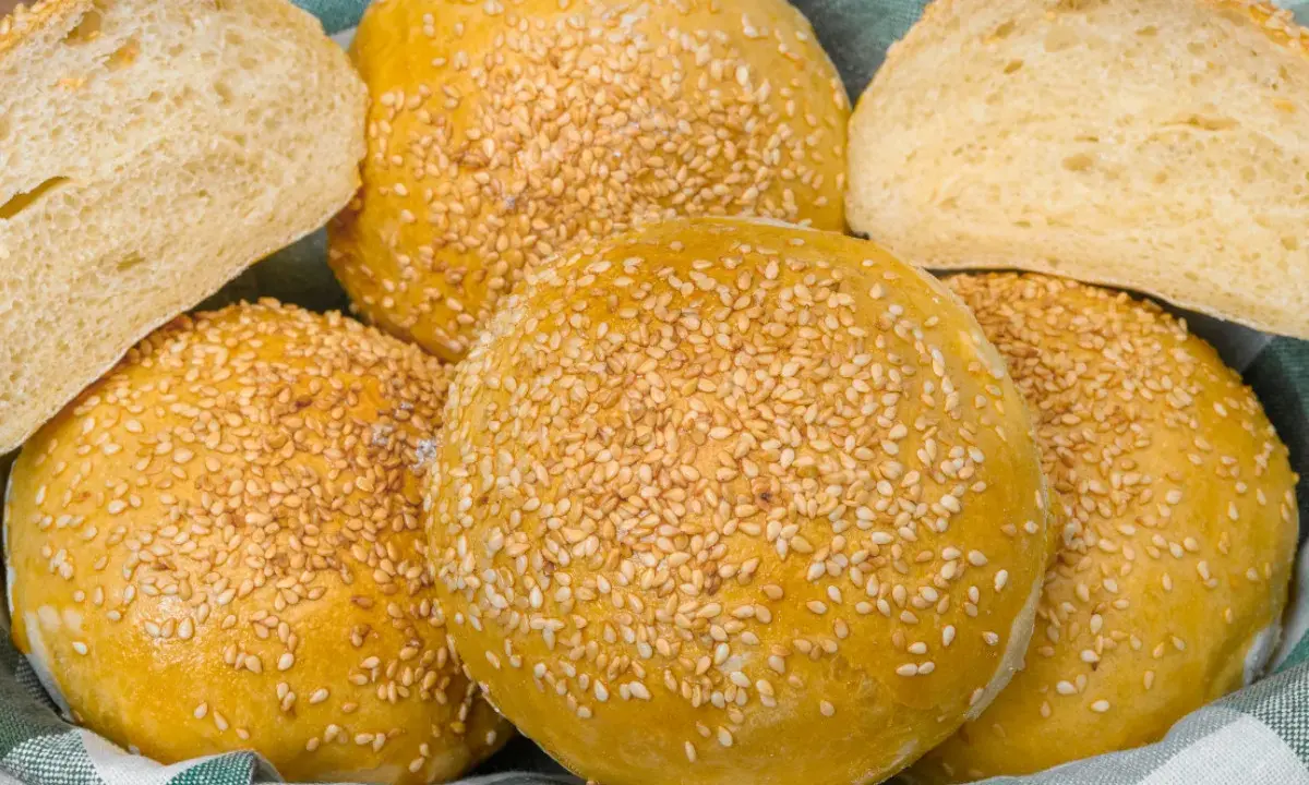 Koszyk pełen pysznych, złotych bułek bez drożdży, posypanych sezamem. Idealne na burgery lub jako dodatek do posiłku.