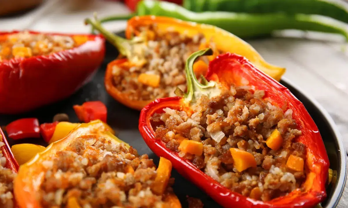 Peperoni ripieni senza carne, un piatto colorato e gustoso. Ripieno di riso e verdure, un'esplosione di sapori.