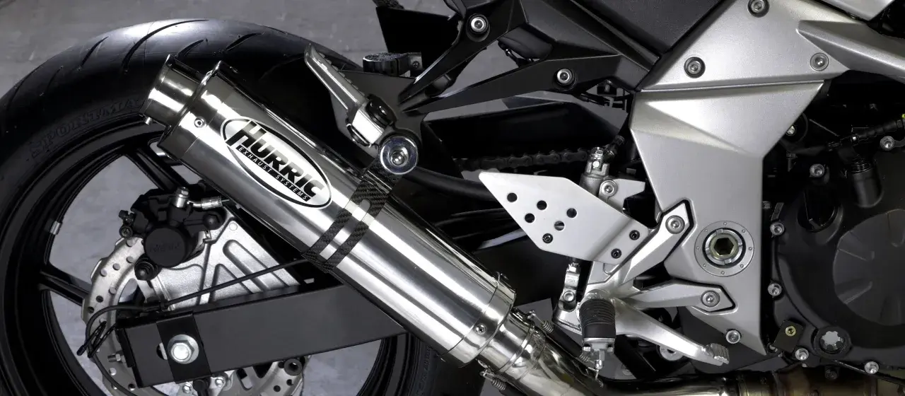Błyszczący tłumik motocyklowy Hurric, element układu wydechowego, który może pomóc w uzyskaniu basowego brzmienia.