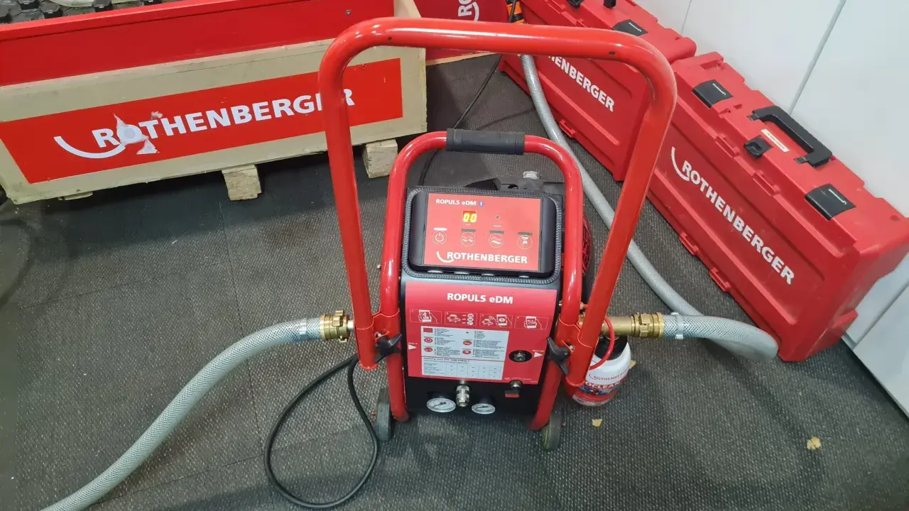 Equipo ROTHENBERGER para limpieza suelo radiante. Máquina roja con mangueras y maletines a juego.