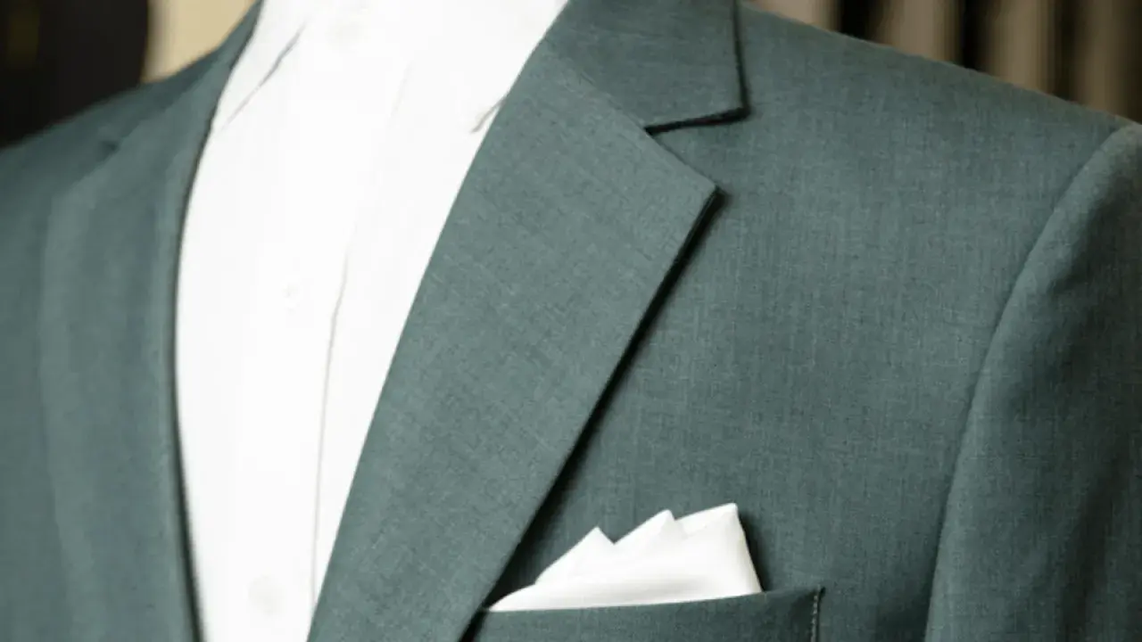 A close-up of a teal suit jacket shows the lapel and a crisp white pocket square.