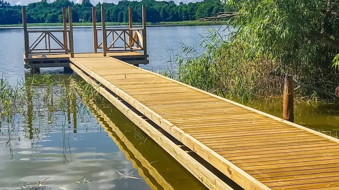 Drewniane pomosty nad jeziorem, idealne na letnie wypady nad wodę. Stawy komercyjne zapraszają do relaksu.