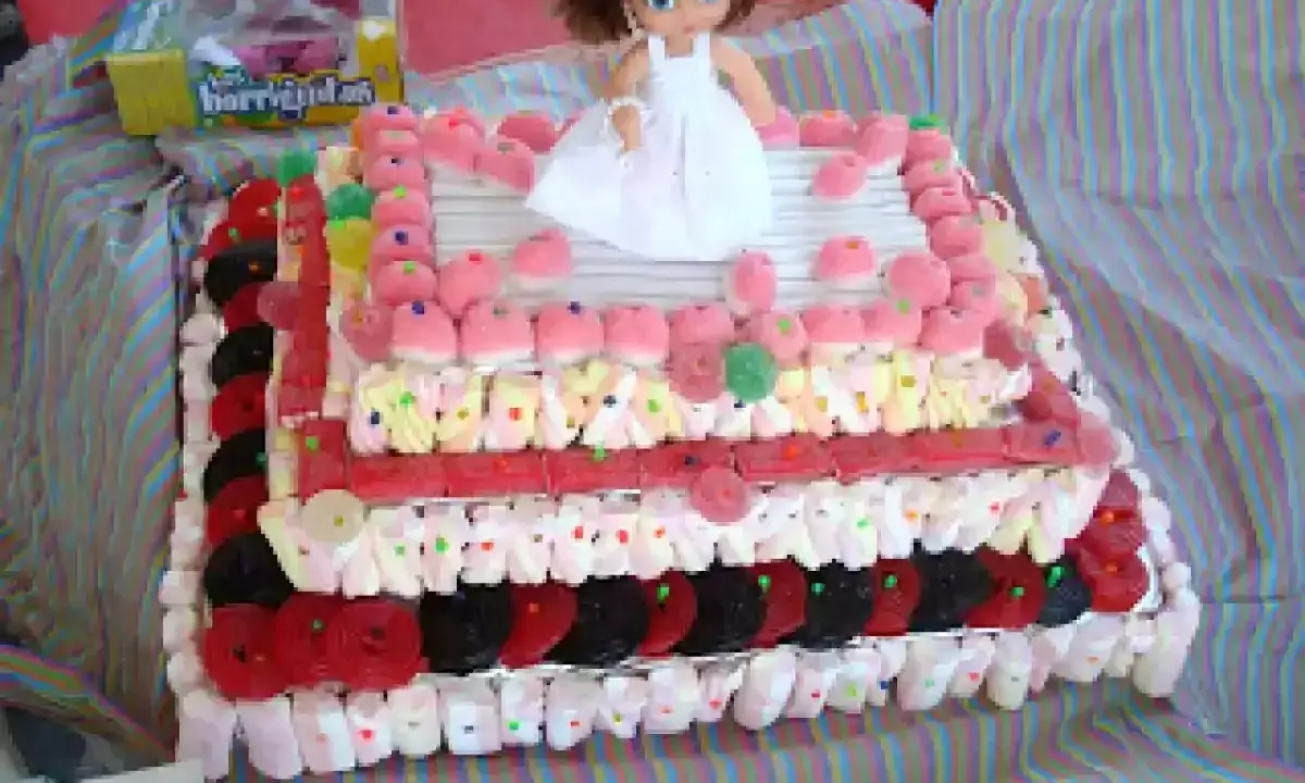 Un pastel de xuxes con una muñeca en la cima, decorado con malvaviscos, gominolas y caramelos.