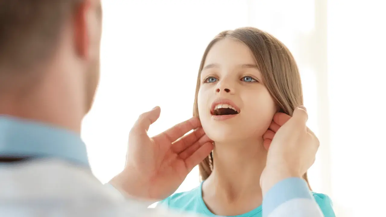 Medico controlla i linfonodi del collo di una bambina.