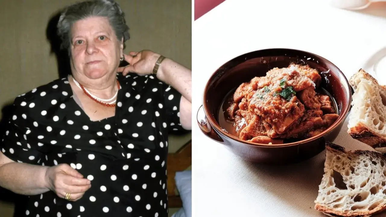 Una donna con un vestito a pois guarda verso la telecamera, accanto a una ciotola di trippa alla romana con pane.
