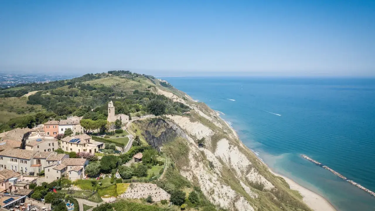 Panoramica aerea di Gabicce Mare, con case arroccate su una collina a picco sul mare Adriatico.