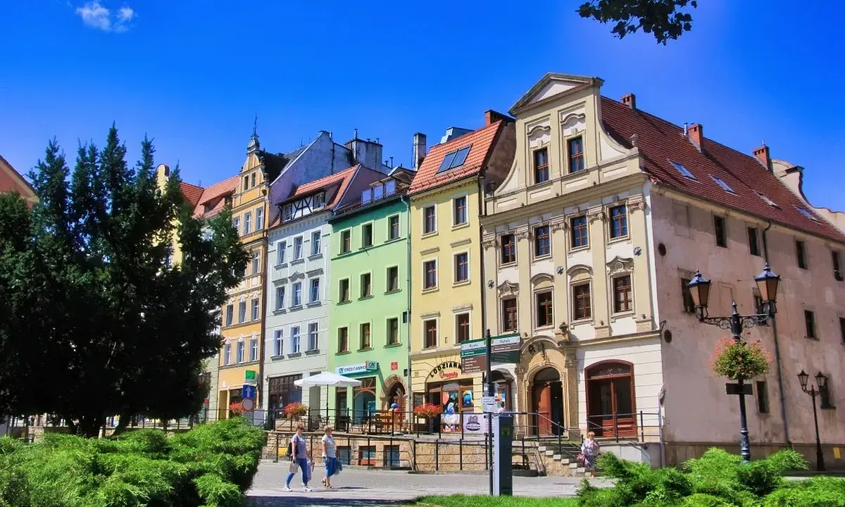 Kolorowe kamienice na rynku w Złotoryi, zachęcające do odkrywania urokliwych zakątków i atrakcji miasta.