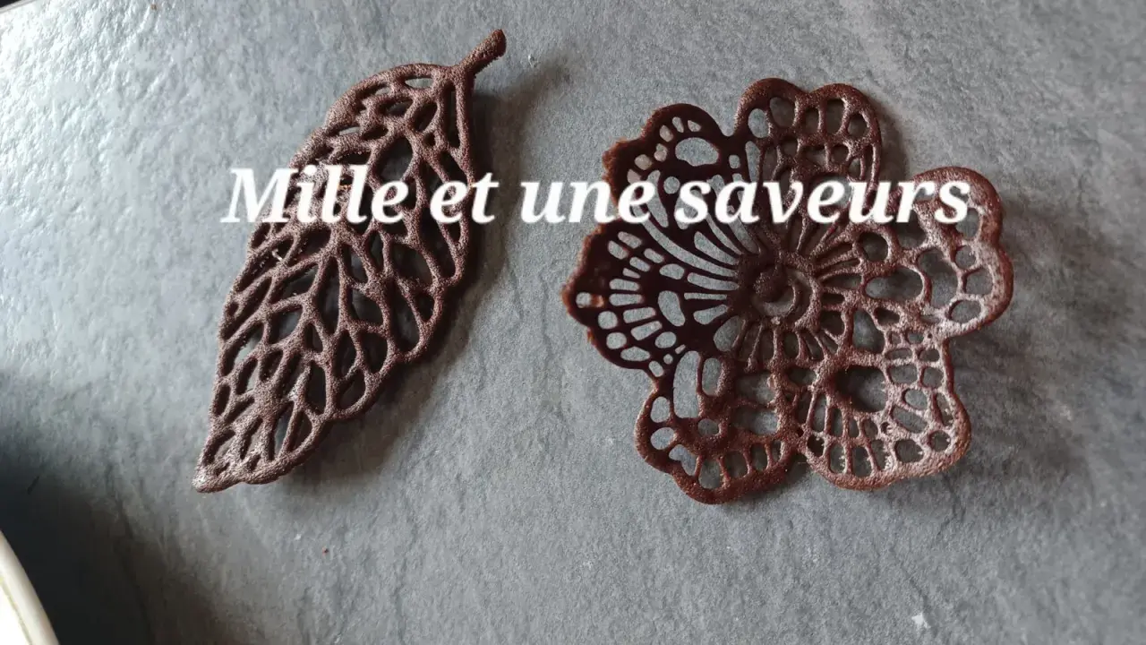 Délicates décorations en chocolat, une feuille et une fleur, réalisées avec une pâte à cigarette fine.