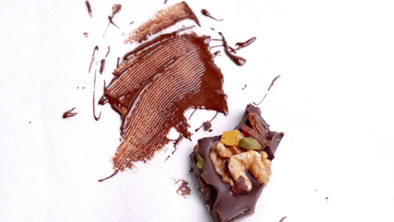Manchas de chocolate derretido y trozo de chocolate con frutos secos. ¿Cómo quitar manchas que no sabes de qué son?
