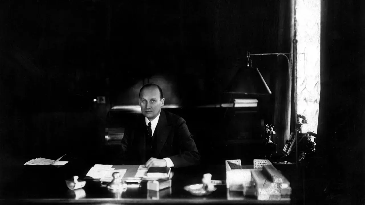 Ivar Kreuger, en svensk ingenjör och industriman, sitter vid sitt skrivbord. En scen som skulle kunna vara från en **Ivar Kreuger film**.
