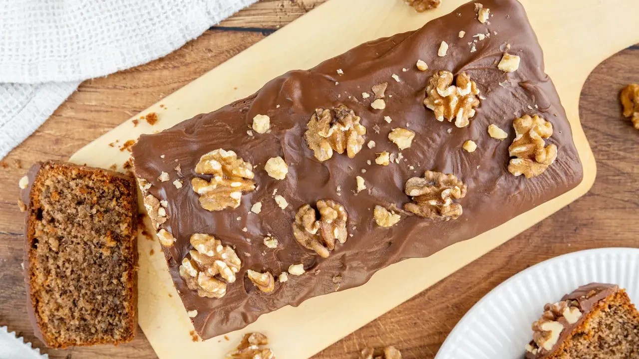 Saftiger Walnusskuchen mit Schokoladenglasur und ganzen Walnüssen. Dieses Rezept für Walnusskuchen ist ein Genuss!