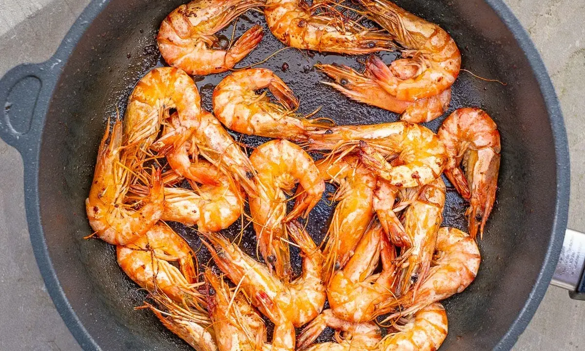 Saftige, tiefgefrorene Garnelen mit Schale werden in einer Pfanne zubereitet. Sie sind perfekt für ein schnelles Abendessen.