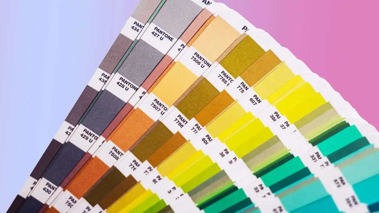 Próbnik kolorów Pantone prezentuje bogactwo barw, od stonowanych szarości po jaskrawe zielenie i żółcie. To narzędzie niezbędne w praktycznym zastosowaniu teorii koloru.