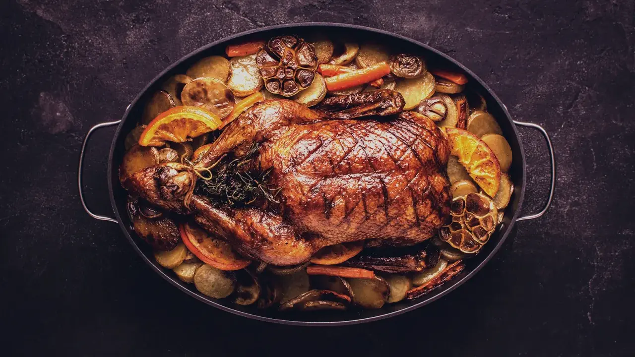 Ein goldbraun gebratener Gänsebraten mit Kartoffeln, Orangen und Knoblauch. Perfekt für den Rotwein zur Gans.