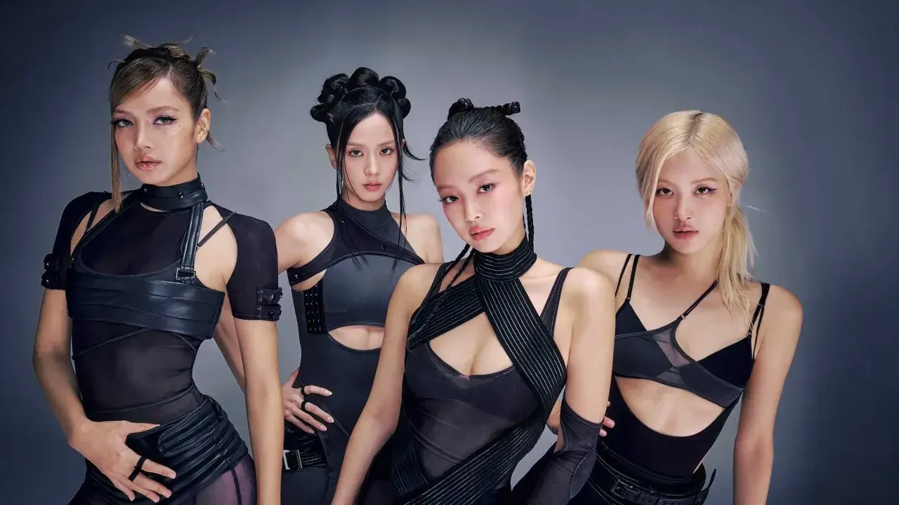 Medlemmar av Blackpink poserar i futuristiska svarta outfits.