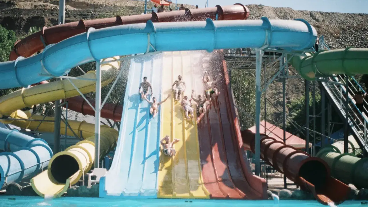 Gente disfrutando de toboganes de agua en lo que parece ser el mejor parque acuático de Europa.
