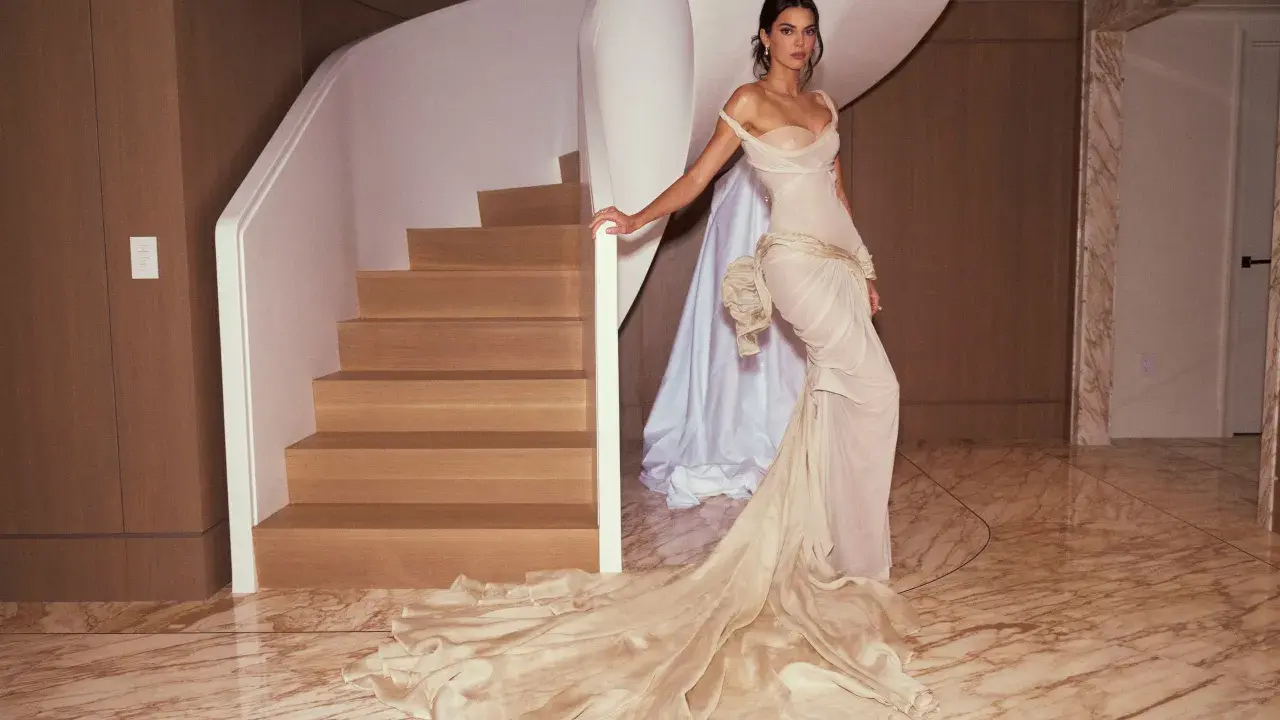 Kendall Jenner in a flowing gown, posing by a spiral staircase, a vision of Met Gala elegance.