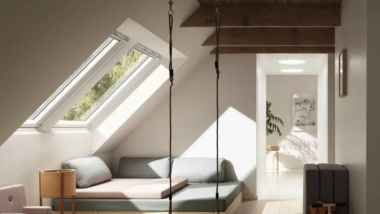 Aménagement d'un grenier lumineux avec balançoire, lit bas et coin jeux. Idées pour comment aménager un grenier en espace cosy.