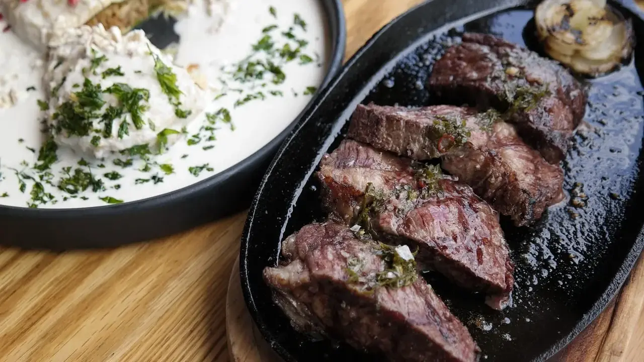 En saftig argentinsk grillfest med perfekt stekt kött och en krämig rätt med örter.