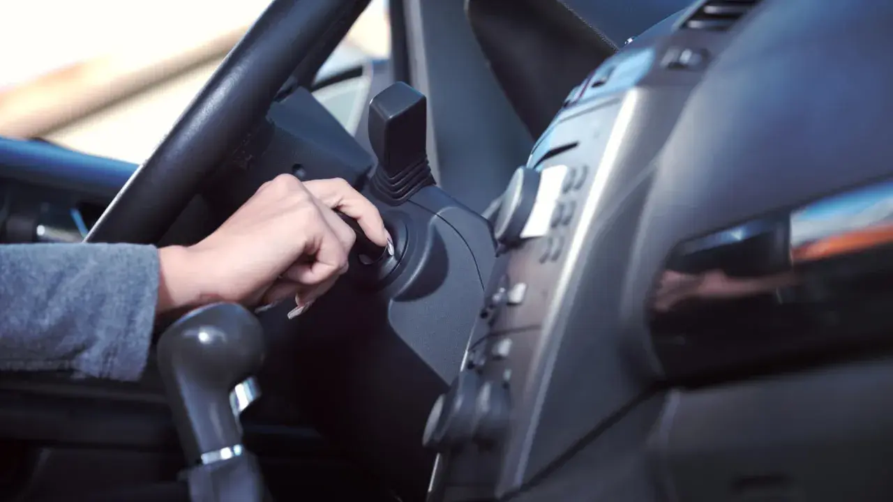 Mano girando la llave de contacto. Es malo tener el coche arrancado mucho tiempo, consume combustible y contamina.