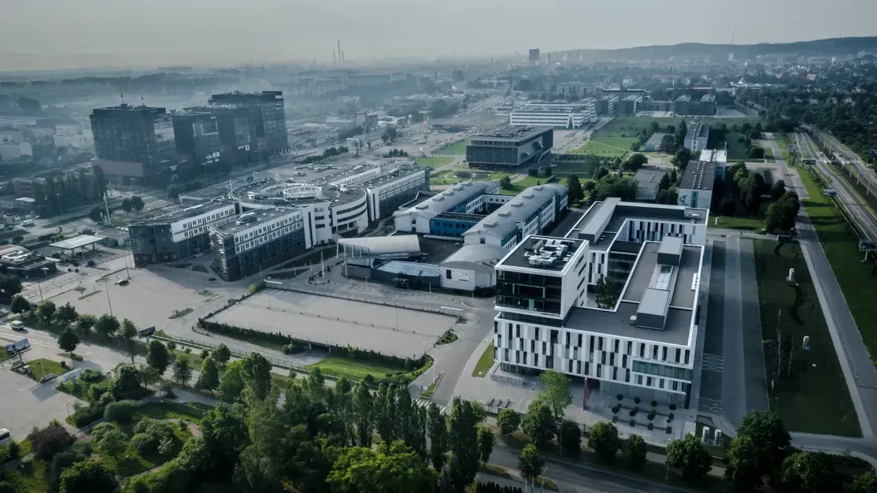 Nowoczesne budynki ULO Gdańsk w otoczeniu zieleni i infrastruktury miejskiej.