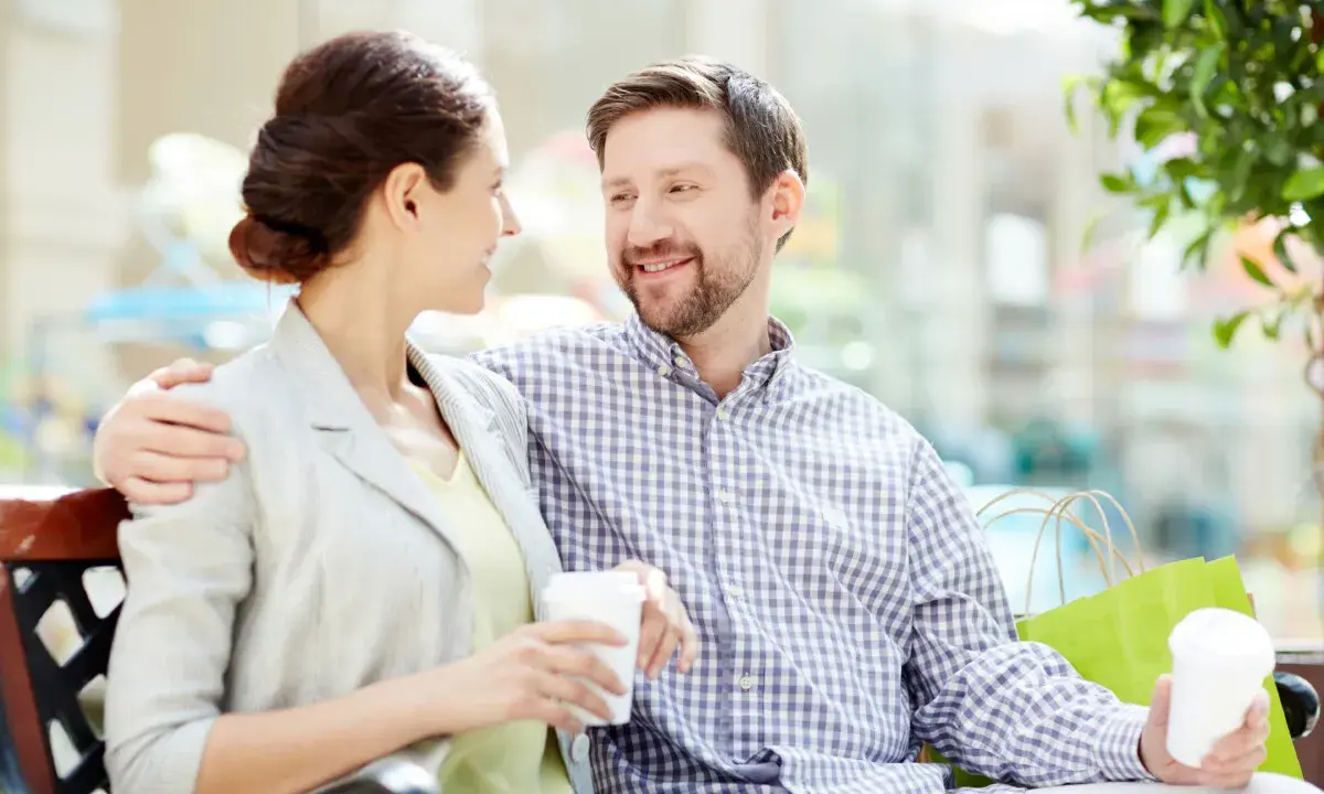 Pareja sonriente compartiendo un café, un ejemplo de comunicación efectiva.