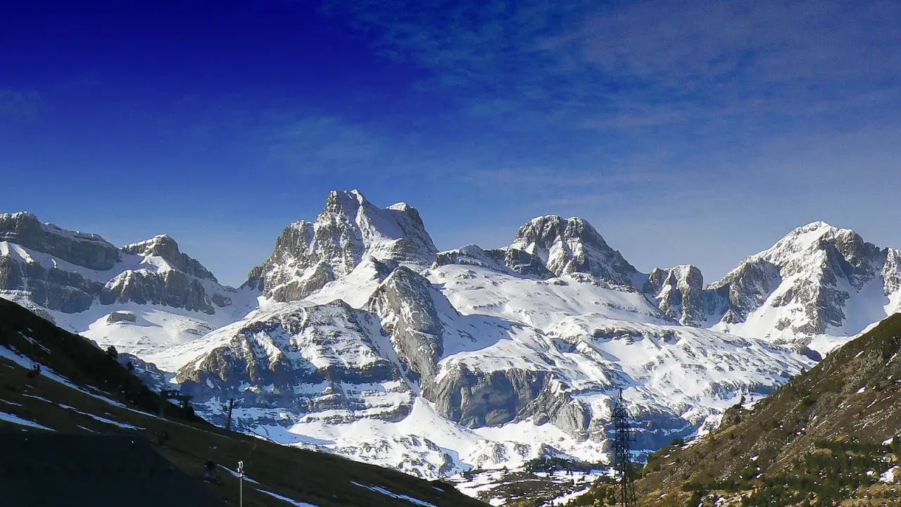 Majestuosas cumbres nevadas en Candanchú, un paisaje de verano que invita a la aventura.