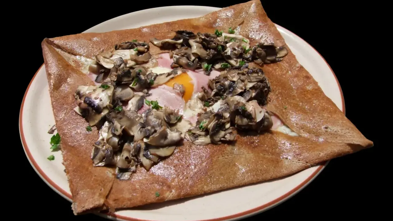 Galette complète garnie de jambon, œuf, champignons et persil. Une recette savoureuse pour un repas rapide.