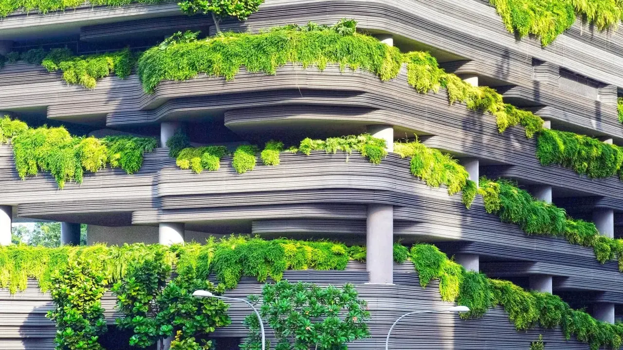 Edificio ecológico con balcones curvos cubiertos de exuberante vegetación verde, creando un oasis urbano.