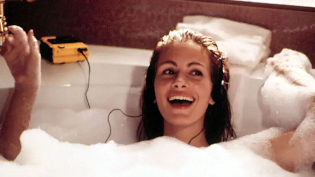 Julia Roberts lacht in einer Schaumbadewanne, hört Musik über Kopfhörer. Sie fragt sich, wie oft Haare waschen wohl nötig ist, um so strahlend auszusehen.