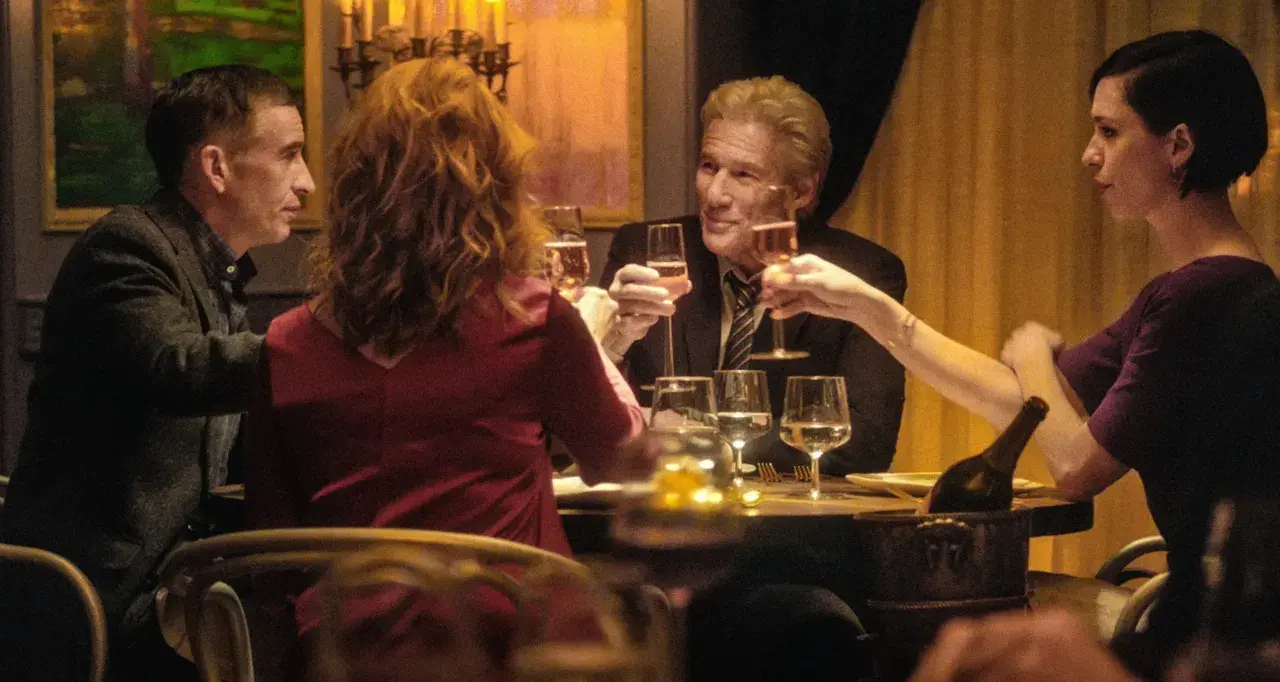 Quattro persone brindano durante una cena elegante, con bicchieri di champagne e un'atmosfera intima.