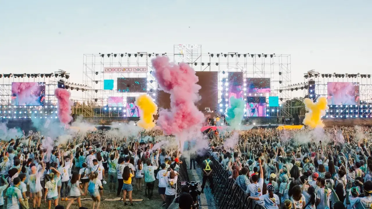 Stor publik njuter av Way Out West lineup med färgpulver i luften.