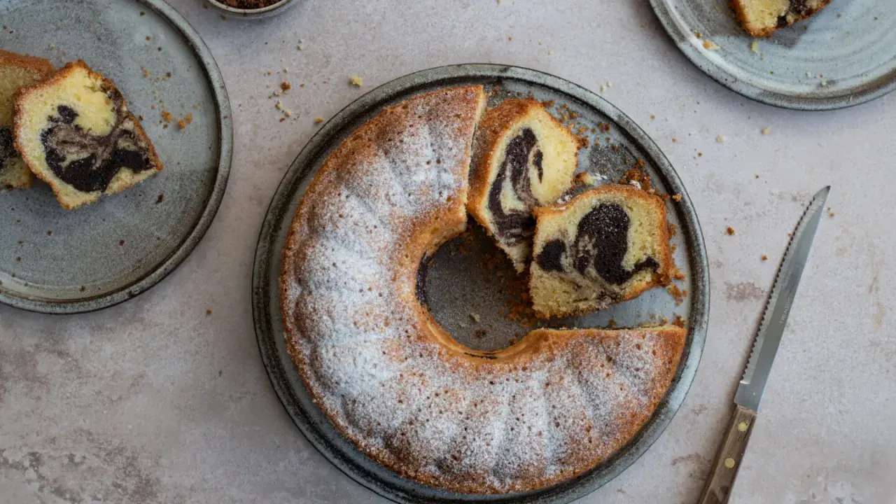 Ein köstlicher Marmorkuchen, frisch gebacken und mit Puderzucker bestäubt. Dieses Marmorkuchen Rezept ist ein Klassiker.