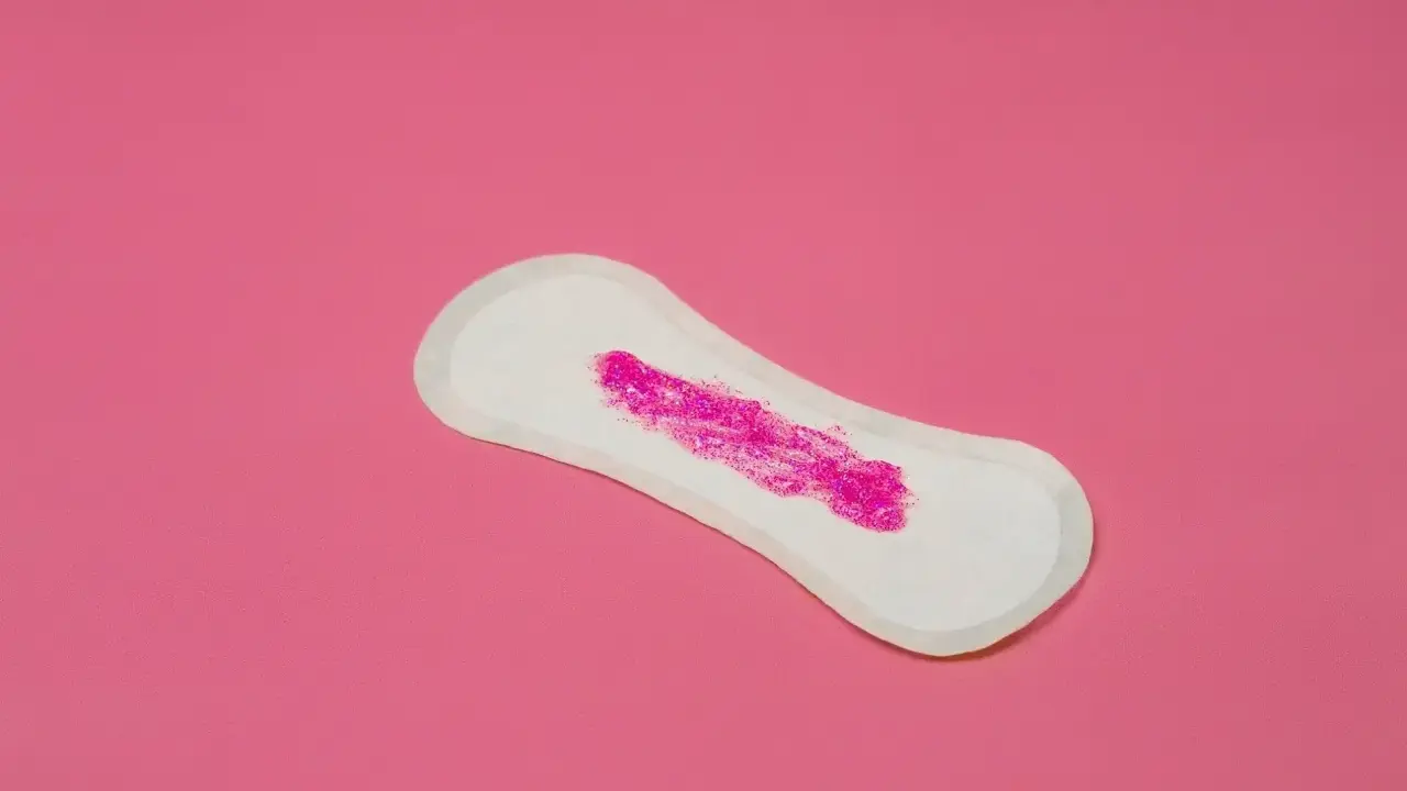 Compresa con brillo rosa simulando que la regla solo mancho al limpiarme.