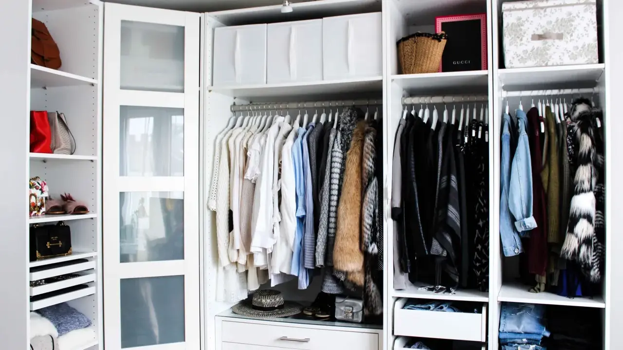 Ordentliche Kleideraufteilung im PAX Kleiderschrank: Hängende Kleidung, Taschen und Boxen sind übersichtlich sortiert.