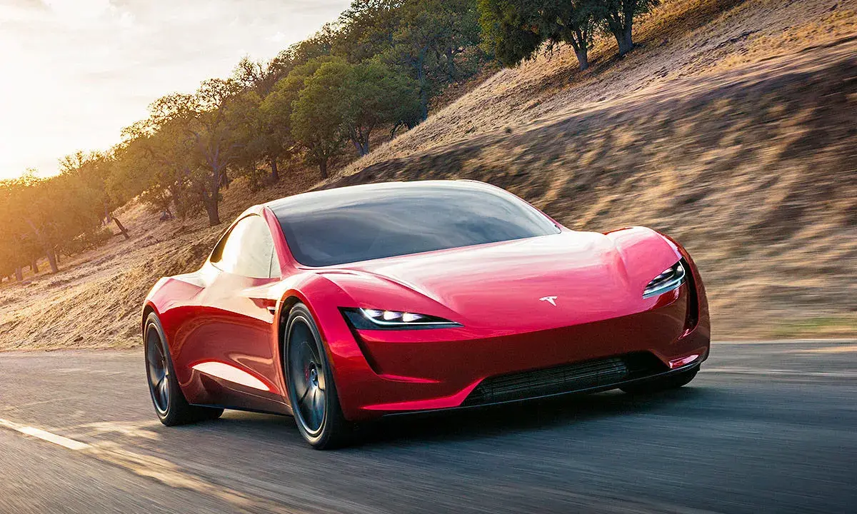 Roter Tesla Roadster rast auf einer Straße, die Beschleunigung von 0 auf 100 km/h ist atemberaubend.