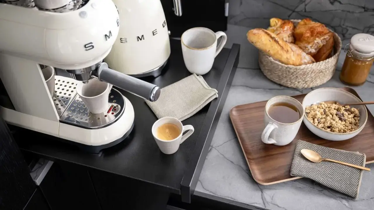 Kaffeebar zu Hause einrichten: Espresso, Müsli und Gebäck auf einem Tablett.