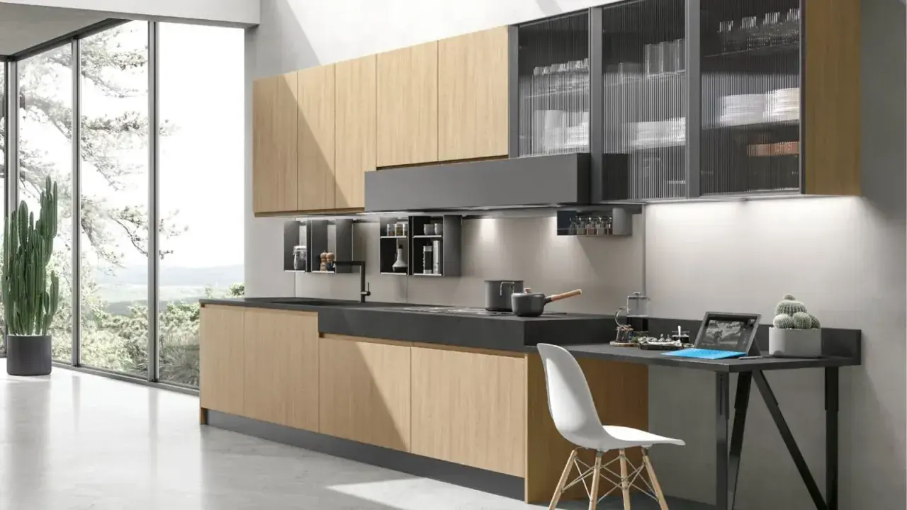 Cucina moderna con ante in legno chiaro e pensili in vetro rigato. Ottime idee cucina piccola per sfruttare ogni spazio.