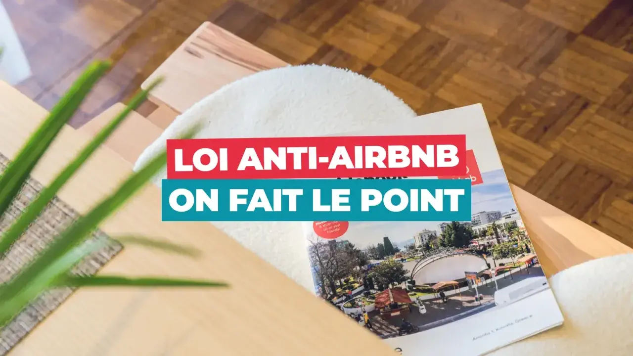 Un magazine sur la **loi Airbnb** est posé sur un meuble en bois. Le titre "Loi anti-Airbnb, on fait le point" est bien visible.