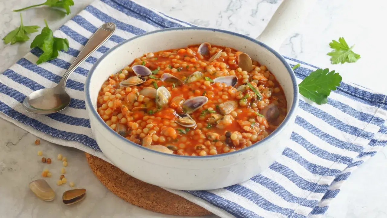 Fregola sarda con vongole e cozze, un classico da provare per scoprire cosa mangiare in Sardegna.