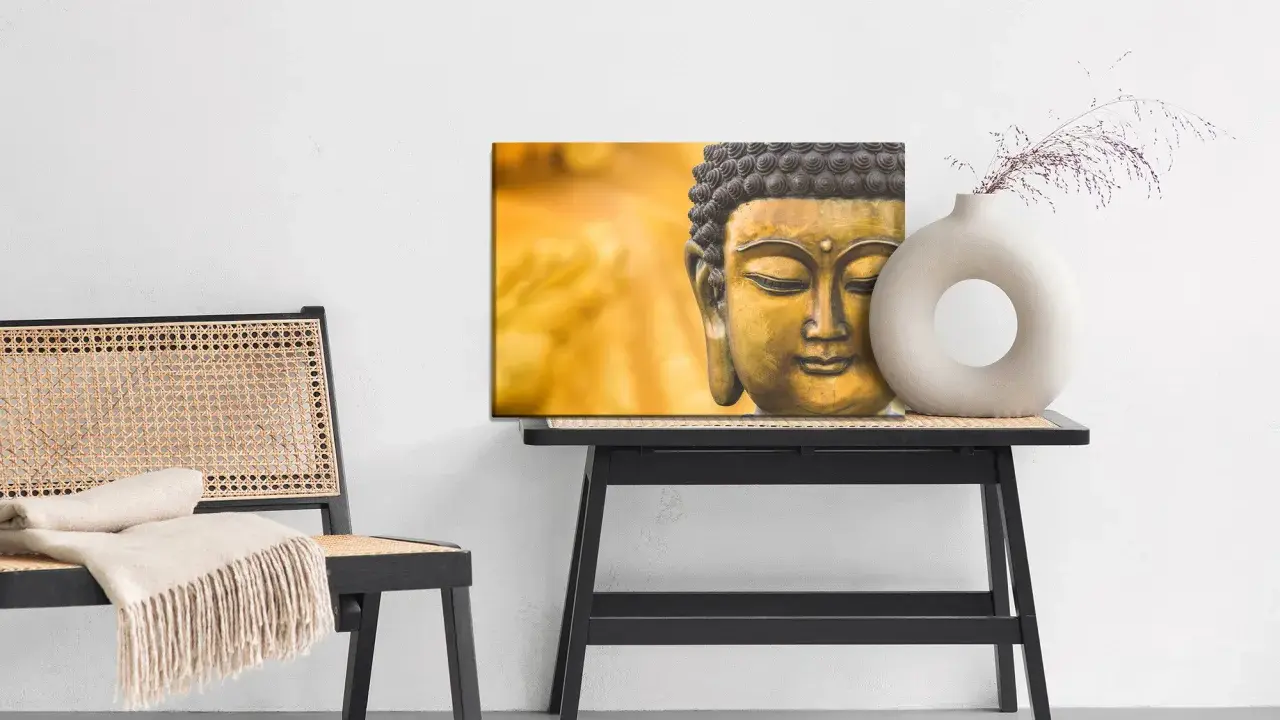 Buddha-tavla med matt material bredvid en stol med pläd och ett bord med en vas.