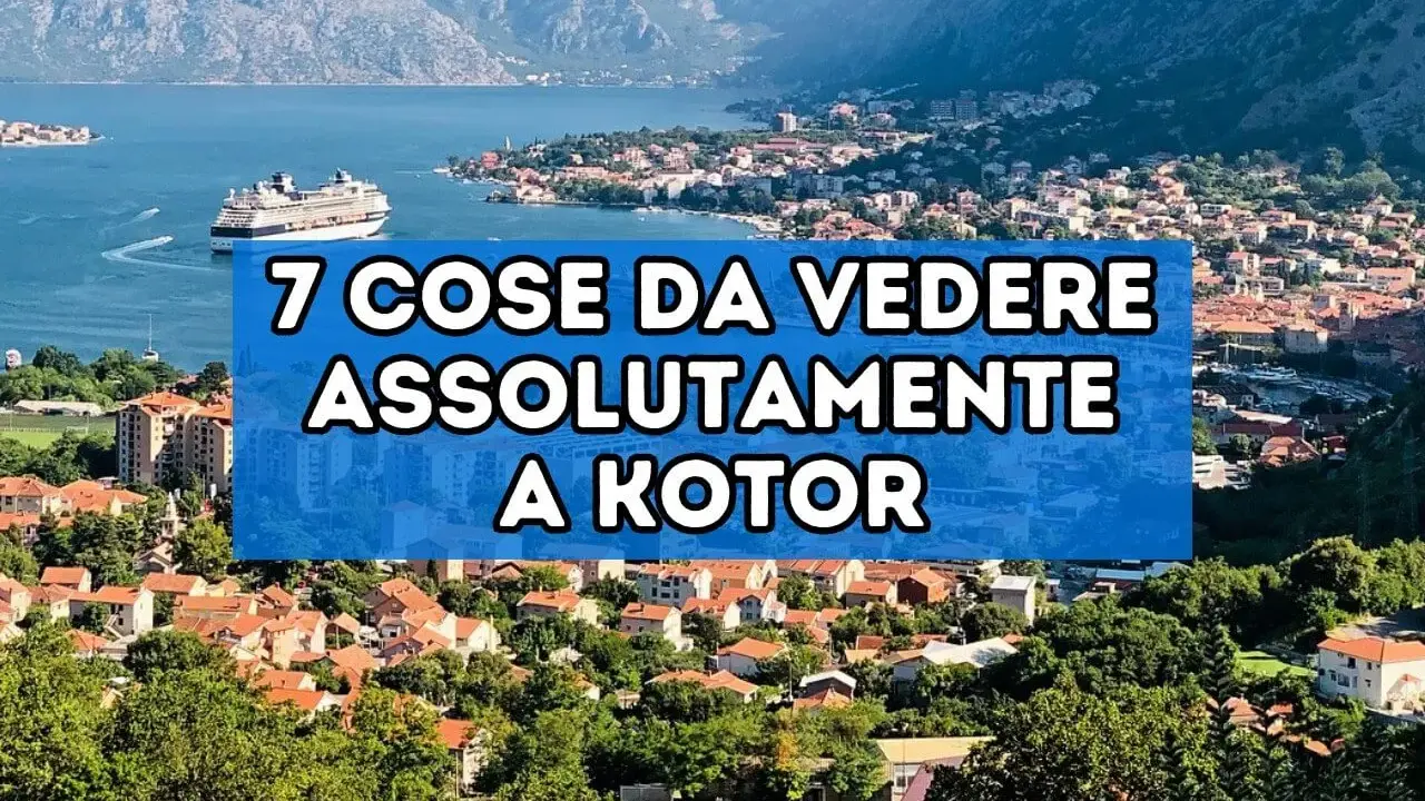 Panoramica del centro storico di Kotor, con un grande transatlantico nel golfo e montagne sullo sfondo.