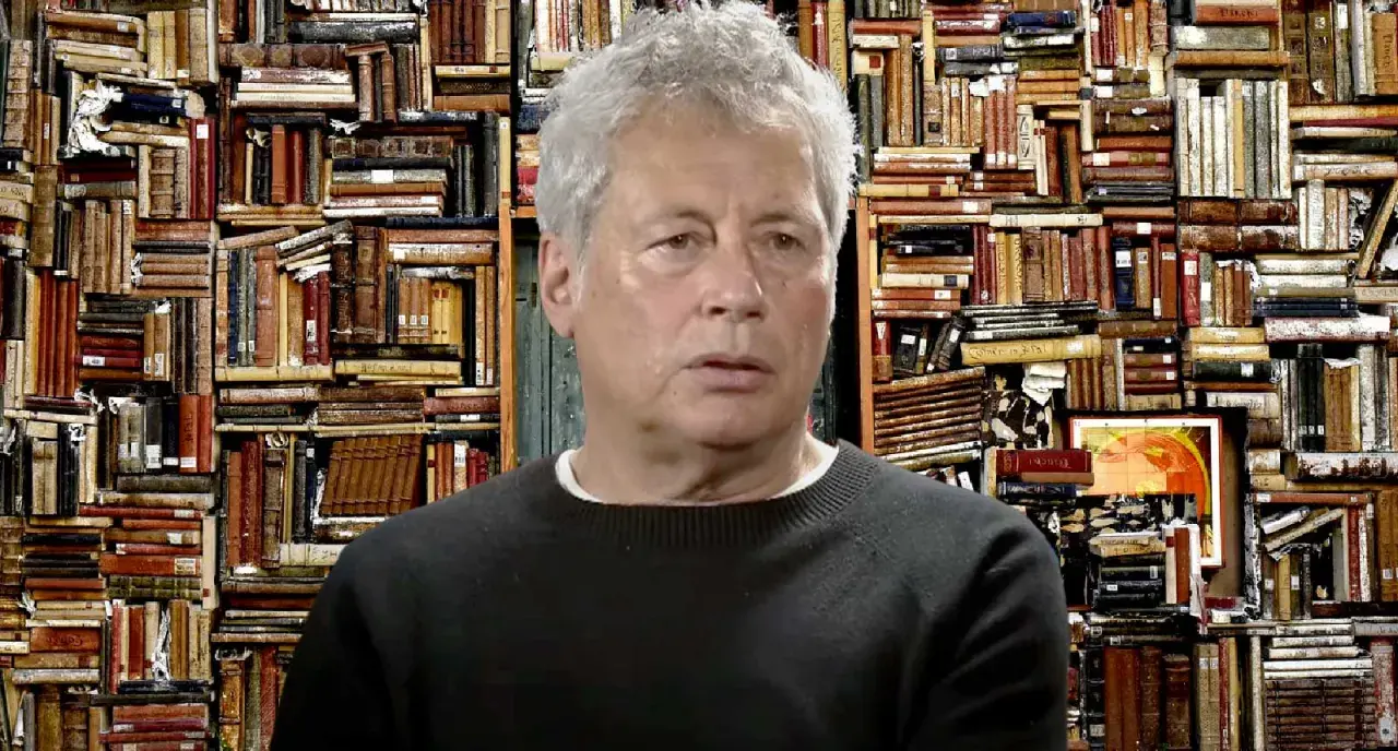 Un uomo con capelli grigi davanti a uno sfondo di libri antichi, forse ispirato ai libri di Alessandro Baricco.