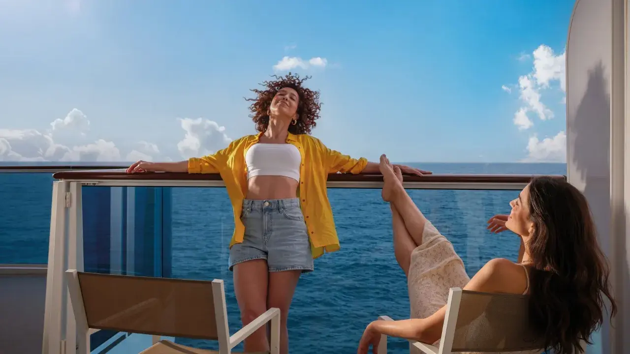 Due donne si godono il sole sul ponte di una nave, con il mare blu all'orizzonte. Una carta costa ideale per una vacanza rilassante.